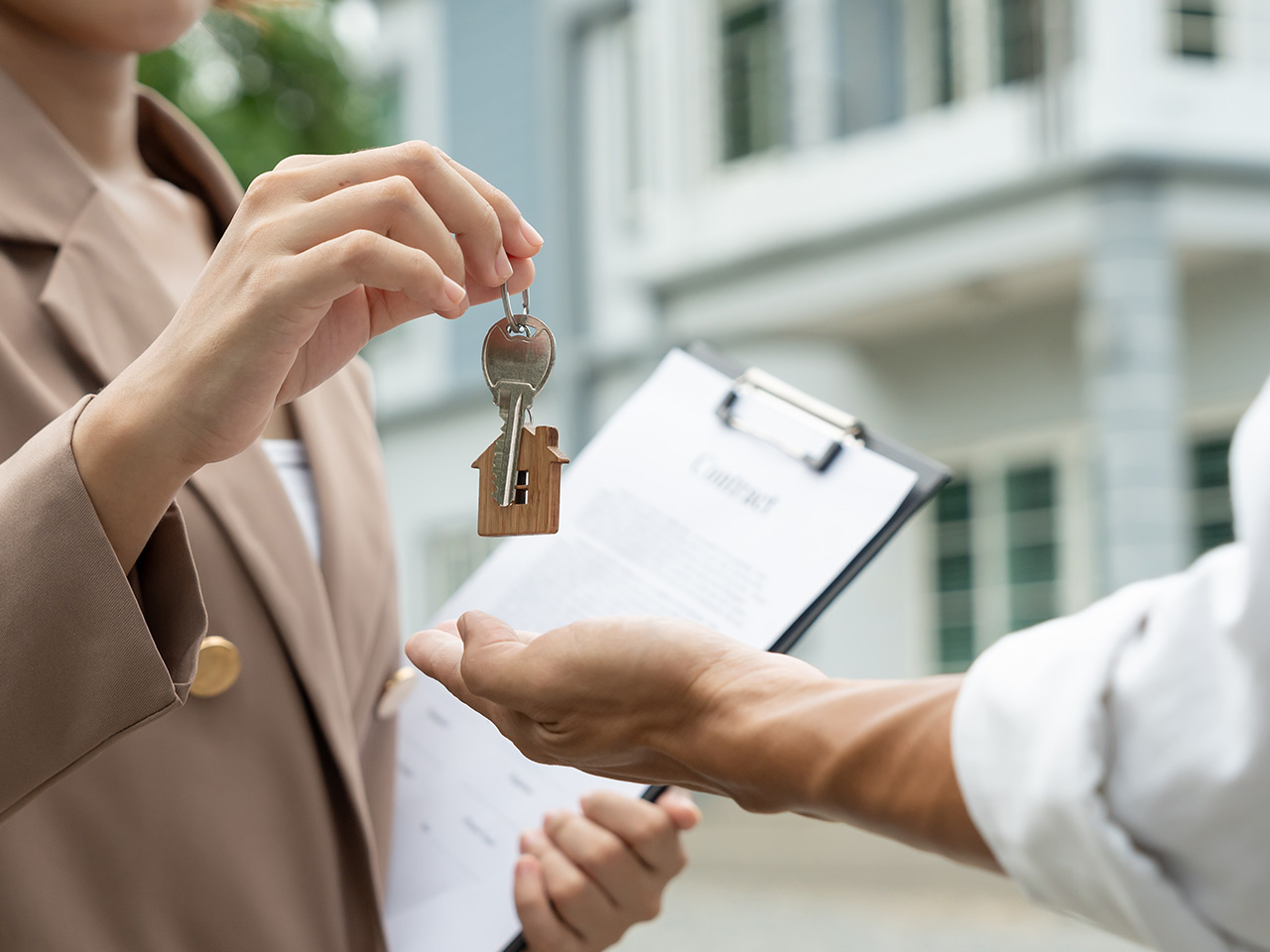 Agent handing over keys to sold property